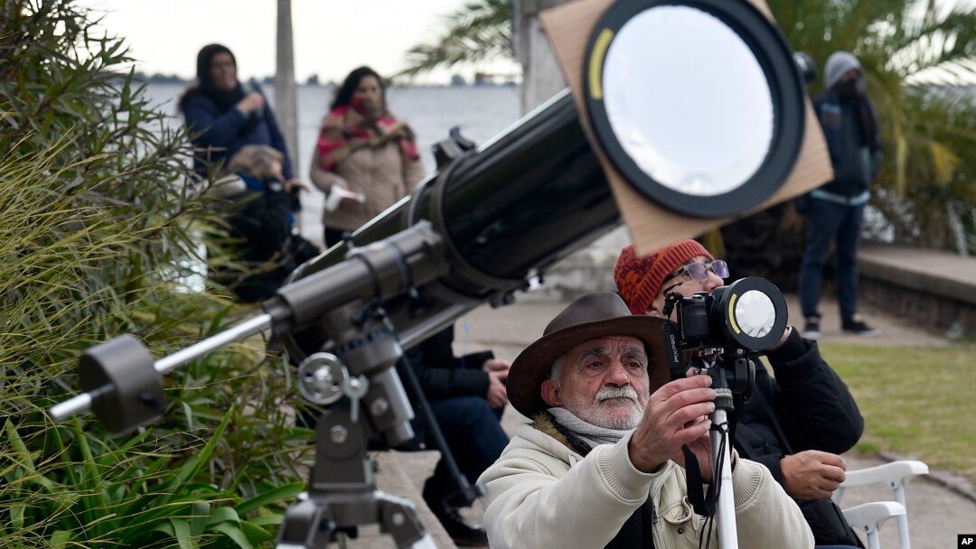  Un hombre toma fotos de un eclipse solar total en Chascomús, Argentina, el martes 2 de julio de 2019. (AP Foto/Gustavo Garello)