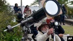  Un hombre toma fotos de un eclipse solar total en Chascomús, Argentina, el martes 2 de julio de 2019. (AP Foto/Gustavo Garello)