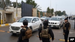 Iraqi security forces stand guard as they check motorists entering the Green Zone, in Baghdad, Iraq, Jan. 8, 2023. 