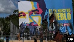 Un hombre camina debajo de una valla publicitaria gigante con la imagen del presidente venezolano Nicolás Maduro, vandalizada durante las fuertes protestas contra los resultados de las elecciones presidenciales de Venezuela en Valencia, Venezuela, el 31 de julio de 2024