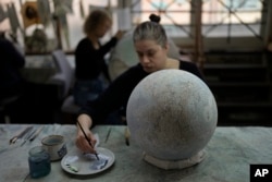 Peter Bellerby made his first globe for his father, after he could not find one accurate or attractive enough. In 2008, he founded Bellerby & Co. Globemakers in London. (AP Photo/Kin Cheung)