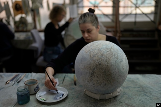 Peter Bellerby made his first globe for his father, after he could not find one accurate or attractive enough. In 2008, he founded Bellerby & Co. Globemakers in London. (AP Photo/Kin Cheung)