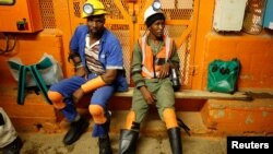 FILE - Miners take a break in a waiting area deep underground at Sibanye Gold's Masimthembe shaft in Westonaria, South Africa, April 3, 2017. 