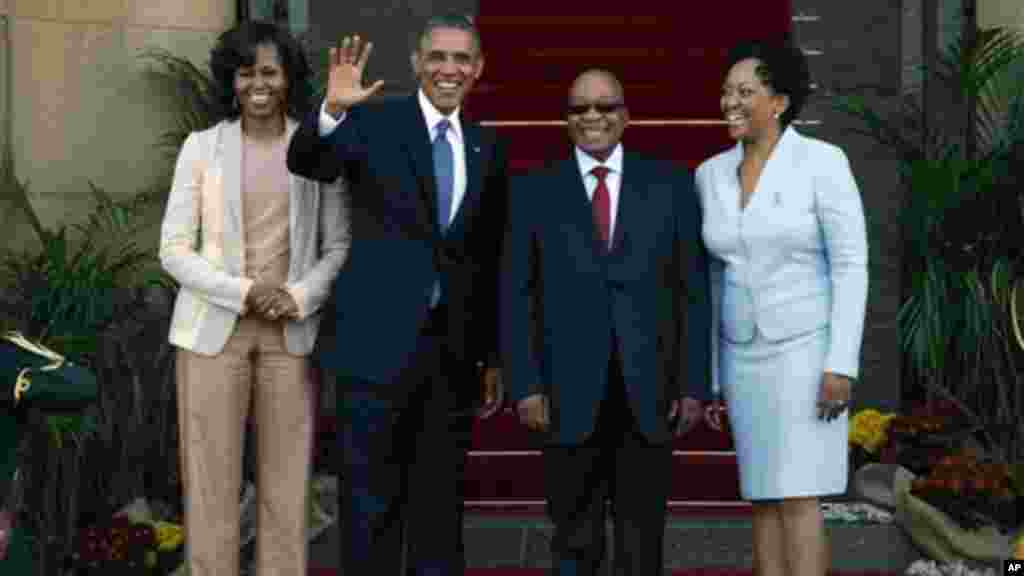 U.S. President Barack Obama flanked by First Lady Michelle Obama, left, waves with South African President Jacob Zuma.