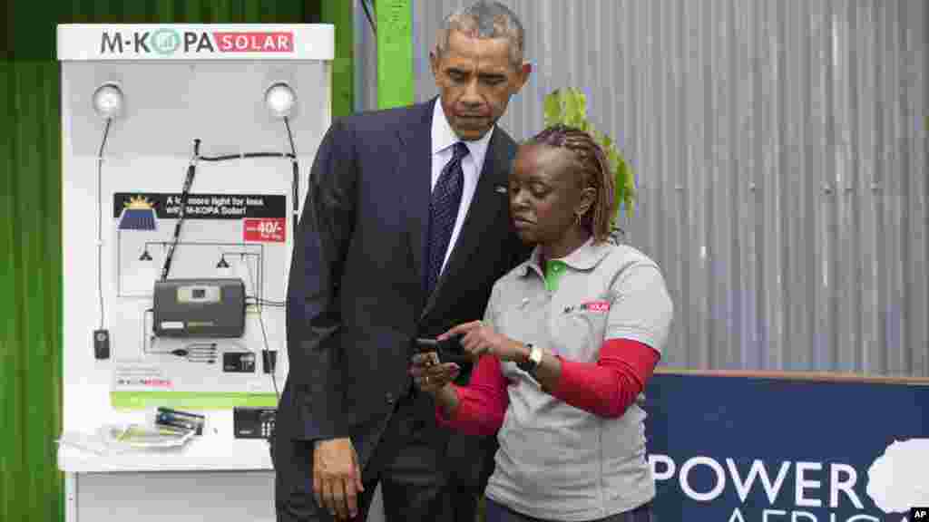  Rais Barack Obama anaangalia jinsi ya kufanya malipo kwa njia ya simu ya mkononi na matumizi ya nishati ya nguvu za jua wakati wa maonyesho ya Power Africa Innovation Fair, Jumamosi, Julai 25, 2015 mjini Nairobi. ziara ya Obama Kenya imelenga masuala ya biashara na uchumi, pamoja na usalama na ushirikiano katika kukabiliana na ugaidi.