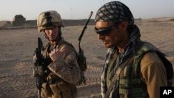 FILE - U.S. Marine 1st Lt. Zachary Bennett talks with an Afghan interpreter during a joint patrol in Helmand province, southern Afghanistan, Sept. 19, 2009.