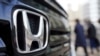 Beberapa pengunjung berjalan di dekat mobil buatan Honda yang ditampilkan di sebuah showroom di Tokyo, pada 8 Februari 2022. (Foto: AP/Eugene Hoshiko)