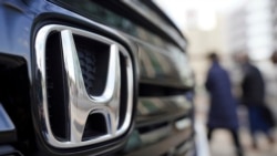 Beberapa pengunjung berjalan di dekat mobil buatan Honda yang ditampilkan di sebuah showroom di Tokyo, pada 8 Februari 2022. (Foto: AP/Eugene Hoshiko)