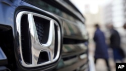 Beberapa pengunjung berjalan di dekat mobil buatan Honda yang ditampilkan di sebuah showroom di Tokyo, pada 8 Februari 2022. (Foto: AP/Eugene Hoshiko)