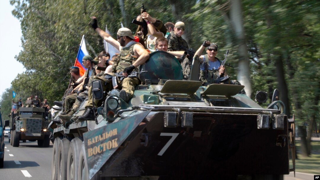 Pemberontak pro-Rusia mengendarai tank mereka di Donetsk.
