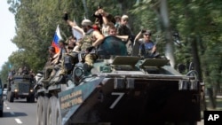 Pemberontak pro-Rusia mengendarai tank mereka di Donetsk.