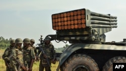 Des soldats des Forces armées de la République démocratique du Congo (FARDC) se tiennent près d'un lance-roquettes multiples mobile à Matombo, à 35 km au nord de Beni, au Nord-Kivu, le 13 janvier 2018.