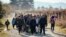 FILE - Migrants and refugees are seen walking after crossing the Greek-Macedonian border near Gevgelija, Nov. 16, 2015. 