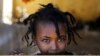 FILE - An Ethiopian girl stands at the window of a temporary shelter, at the Village 8 refugees transit camp, which houses Ethiopian refugees fleeing the fighting in the Tigray region, near the Sudan-Ethiopia border.