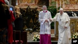 El maestro de ceremonias litúrgicas pontificias, el sacerdote italiano Guido Marini ayuda al Papa Francisco después de que pronunció su Bendición Urbi et Orbi, luego de la Misa de Pascua en la Basílica de San Pedro en el Vaticano el 4 de abril de 2021. 