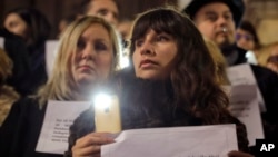Romanian magistrates stand holding copies of their professional oath during a silent protest outside the Bucharest Court of Appeal in Bucharest, Romania, Dec. 18, 2017. 