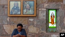 A member of the Mescalero Apache Tribe prays during a Mass at the St. Joseph Apache Mission church in Mescalero, New Mexico, July 14, 2024.