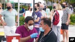 میامی بیچ کے ایک طبی مرکز میں لوگ کرونا سے بچاؤ کی ویکسین لگوا رہے ہیں۔ 4 اگست 2021