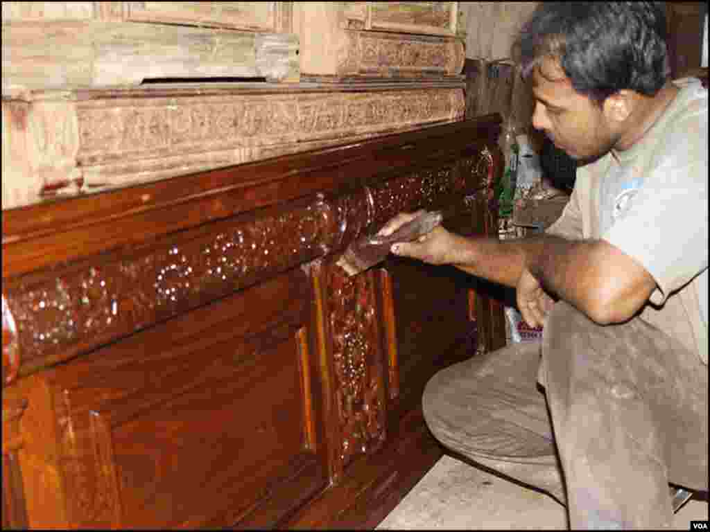 ایک کاریگر فرنیچر پر پالش کر رہا ہے