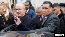 FILE - Palestinian Prime Minister Rami Hamdallah waves as he get into his car, near Hebron, in the Israeli-occupied West Bank, Jan. 28, 2019.