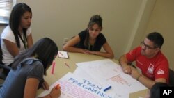 FILE - Christopher Ramirez of Albuquerque helps a group of 16- and 17-year-old students from Roswell create a campaign to battle teen pregnancy in Albuquerque, N.M., July 16, 2009.