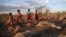 FILE — Maasai children run past a zebra that local residents said died due to drought, as they graze their cattle at Ilangeruani village, near Lake Magadi, in Kenya, on Nov. 9, 2022. Now these years of drought have been linked to climate change by scientists. 