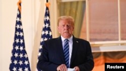 U.S. President Donald Trump poses on the Truman Balcony of the White House after returning from being hospitalized at Walter Reed Medical Center for coronavirus disease (COVID-19) treatment, in Washington, Oct. 5, 2020. 