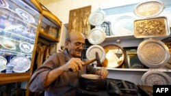 An Iranian man works inside a store in the Bazaar in Isfahan, April 12, 2018. Iran raised its minimum wage recently, but many Iranians fear it's not enough to meet basic needs.