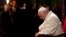Pope Francis bows his heads and closes his eyes during the Via Crucis (Way of the Cross) torchlight procession in Rome, April 18, 2014. 