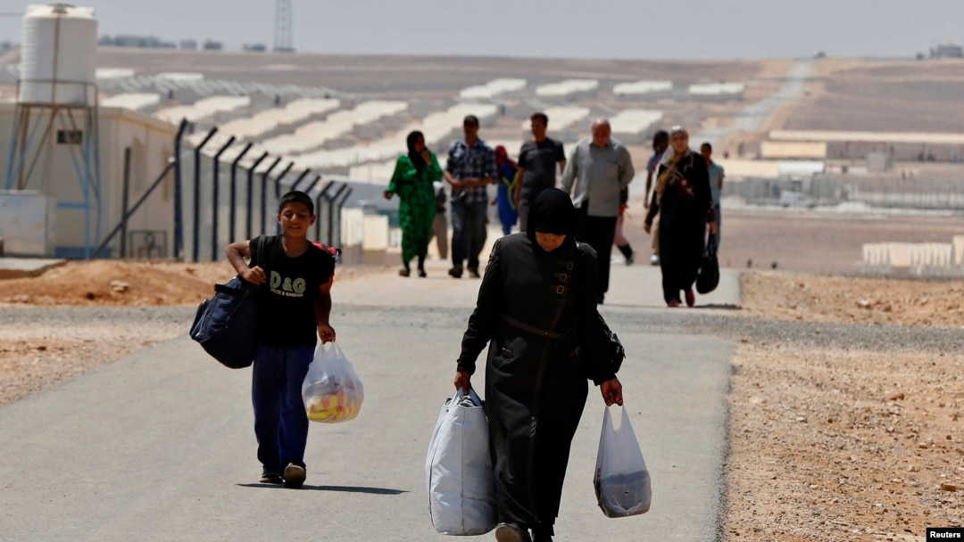 Para pengungsi Suriah membawa barang-barang mereka menuju kamp Azraq di sebelah timur Amman, Yordania (19/8).