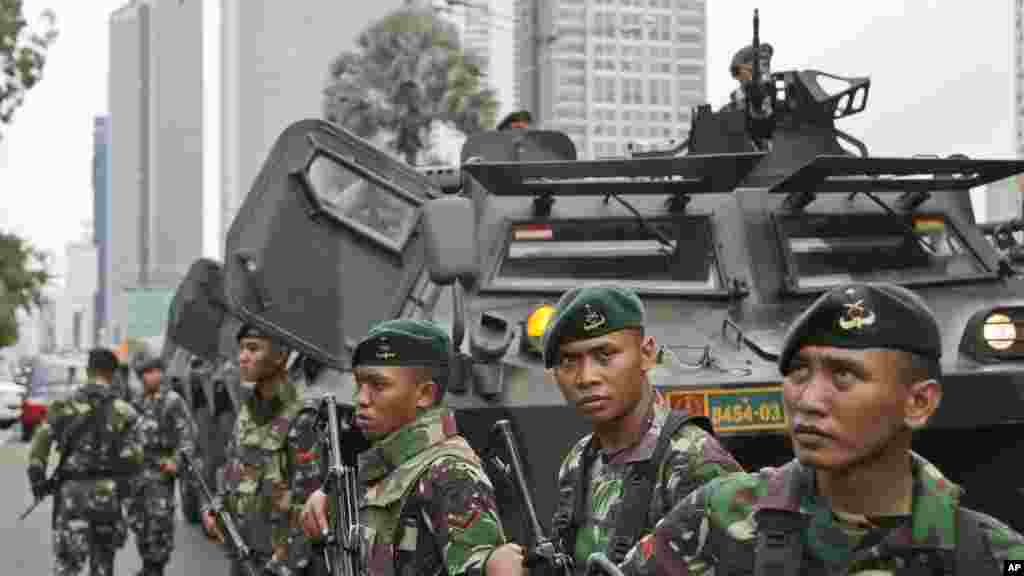 Indonesian soldiers stand guard near the site where an explosion went off in Jakarta, Indonesia Thursday, Jan. 14, 2016. Attackers set off explosions at a Starbucks cafe in a bustling shopping area of downtown Jakarta and waged gun-battles with police Thursday, leaving bodies in the streets as office workers watched in terror from high-rise windows. 