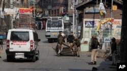 Indian policemen remove road blocks put up by protesters in Srinagar, Indian controlled Kashmir, Oct. 29, 2019.