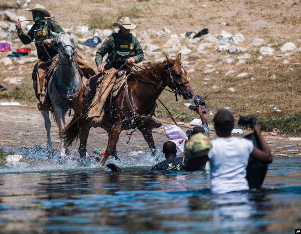 资料照片:美国边境巡逻人员骑马阻止海地移民从格兰德河的墨西哥一侧淌水进入美国边境城市德尔里奥。（2021年9月19日）(photo:VOA)