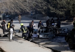 Afghan security officers inspect the site of a bombing attack in Kabul, Jan. 10, 2021.