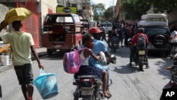 ARCHIVO - Los residentes huyen de sus hogares para escapar de la violencia de las pandillas en el barrio Nazon de Puerto Príncipe, Haití, el jueves 14 de noviembre de 2024. AP