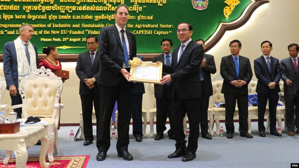 លោក George Edgar ឯកអគ្គរដ្ឋទូតសហភាពអឺរ៉ុបប្រចាំកម្ពុជា និងលោក វេង សាខុន រដ្ឋមន្ត្រីក្រសួងកសិកម្ម រុក្ខាប្រមាញ់ និងនេសាទ ក្នុងពិធីប្រកាសដាក់ឲ្យអនុវត្ត «កម្មវិធីអភិវឌ្ឍន៍វិស័យជលផលឆ្នាំ២០១៩-២០២៣» ភ្នំពេញ ថ្ងៃទី២១ ខែសីហា ឆ្នាំ២០១៩។ (កាន់ វិច្ឆិកា/VOA)