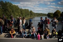 Migrants wait for registration on a bridge across the river Mur between Gornja Radgona, Slovenia and Bad Radkersburg, Austria, about 210 kms (130 miles) south of Vienna, Austria, Sept. 21, 2015.