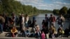 Migrants wait for registration on a bridge across the river Mur between Gornja Radgona, Slovenia and Bad Radkersburg, Austria, about 210 kms (130 miles) south of Vienna, Austria, Sept. 21, 2015. 