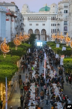 FILE — People gather for a mass Iftar, breaking of fast, in the holy month of Ramadan, in Algiers, Algeria, April 7, 2023.