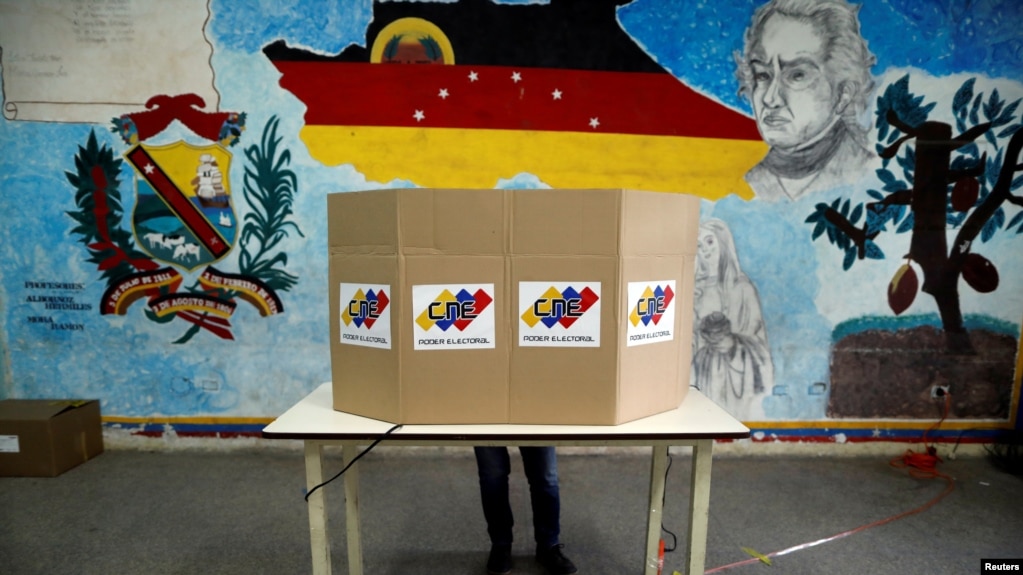 Una persona deposita su voto para las primarias del partido del Gobierno, de cara a las elecciones de noviembre, en Caracas, el 8 de agosto de 2021.
