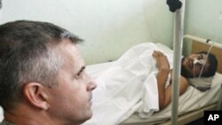 U.S. Rear Admiral Gregory J. Smith, NATO's director of International Security Assistance Force (ISAF) Communication, left, visits an Afghan man, injured by a NATO airstrike, at a hospital in Kunduz, Afghanistan (FILE).