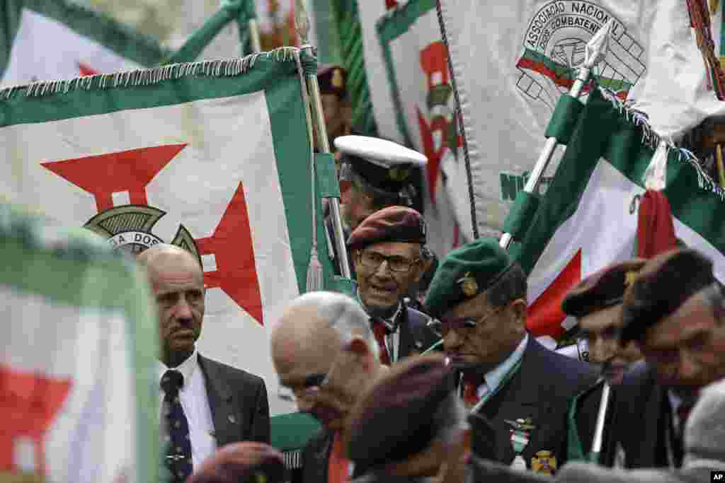 En Portugal, veteranos de guerra cargan sus banderas en un desfile militar en Lisboa. Cerca de 4500 soldados participaron de este evento.