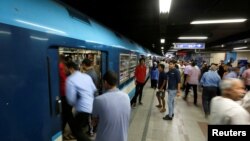 FILE - People wait to board a train at Al Shohadaa metro station in Cairo, Egypt, July 24, 2017. 