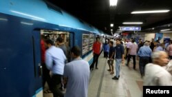 FILE - People wait to board a train at Al Shohadaa metro station in Cairo, Egypt, July 24, 2017. 