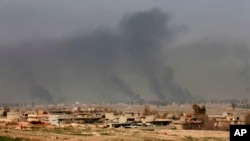 Columnas de humo se aprecian en el oeste de Mosul, luego de un ataque de aviones de la coalición liderada por EE.UU. en Irak.