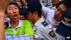 United Progressive Party member Lee Sang-ho, left, is arrested by South Korea's National Intelligence Service at his home in Suwon, south of Seoul, South Korea, Aug. 28, 2013.