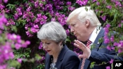 FILE - U.S. President Donald Trump talks with British Prime Minister Theresa May in Taormina, Italy.