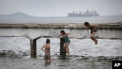 북한 원산의 해변에서 소녀들이 부두 아래로 뛰어내리고 있다. (자료사진)