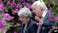 U.S. President Donald Trump talks with British Prime Minister Theresa May in Taormina, Italy.