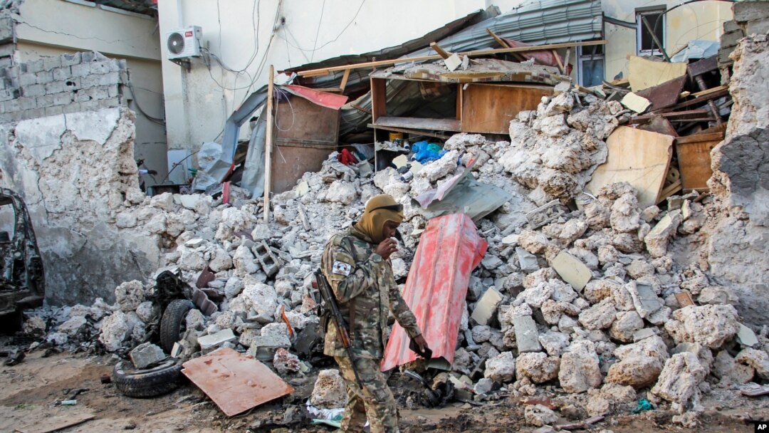 A soldier walks past rubble in the aftermath of an attack on the Afrik Hotel in Mogadishu, Somalia, Feb. 1, 2021. Al-Shabab claimed responsibility for the deadly assault. 